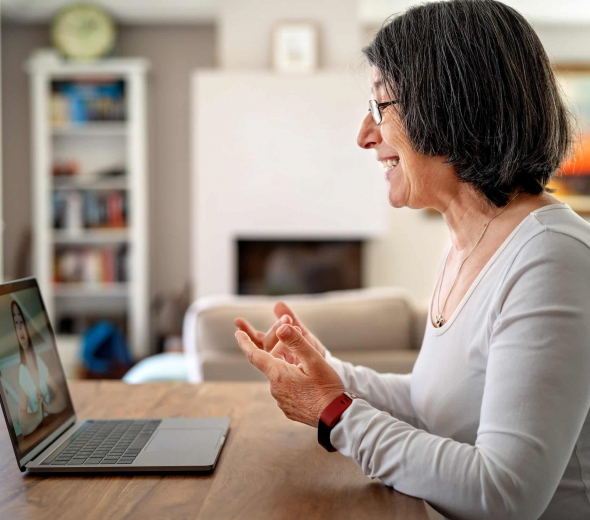 Adult woman having video chat online on laptop with her granddaughter at home during quarantine isolation pandemic. Senior lifestyle. Teacher giving online lesson to student from home.